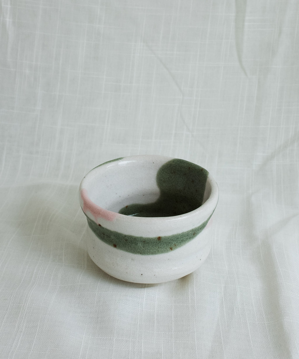 Front view of Japanese Mino matcha bowl in green and pink glaze showing interior design and natural brush texture