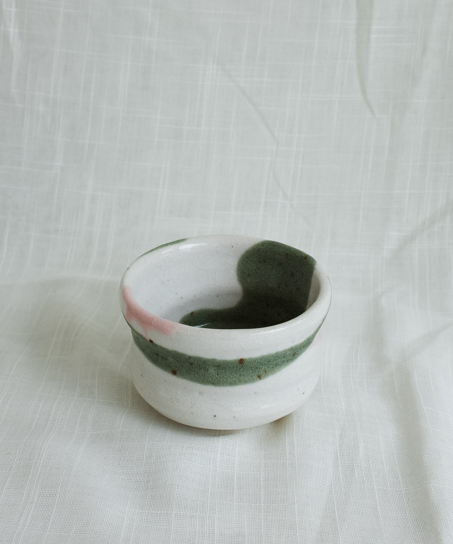 Front view of Japanese Mino matcha bowl in green and pink glaze showing interior design and natural brush texture