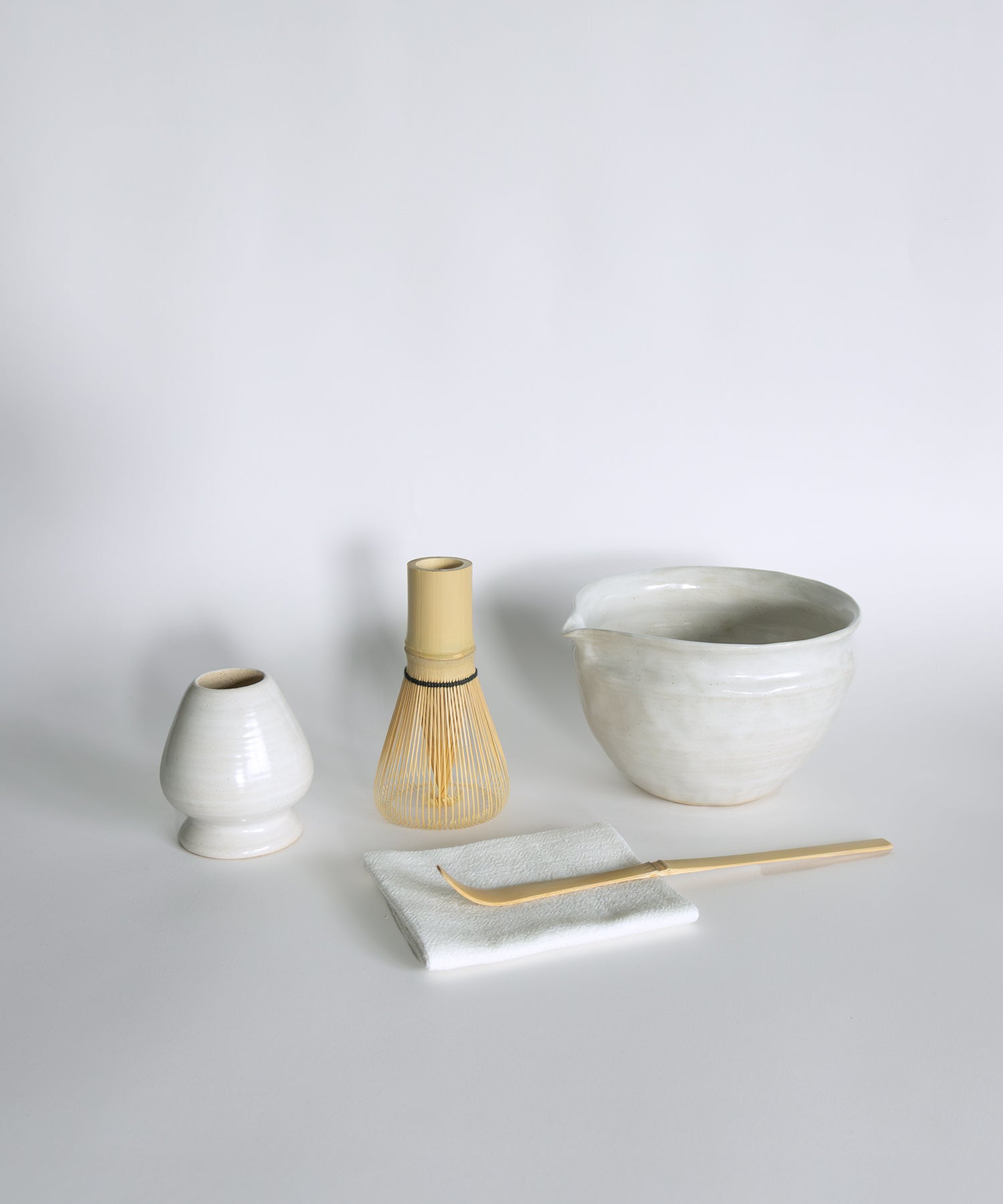 Matcha Whisk Set featuring ceramic bowl, bamboo whisk, scoop, whisk holder and tea towel.
